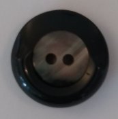 Knapp 23 mm Ø svart/silvrigt i mitten på knapp.